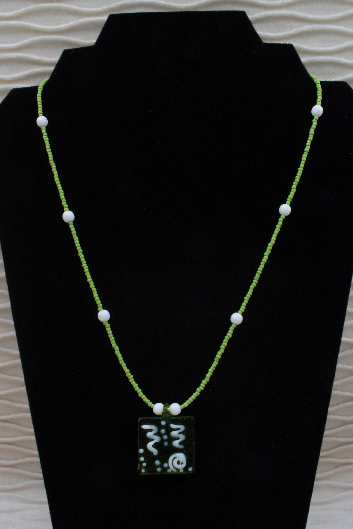A Green Glass Pendent Adorned on a Dainty Green Beaded Necklace